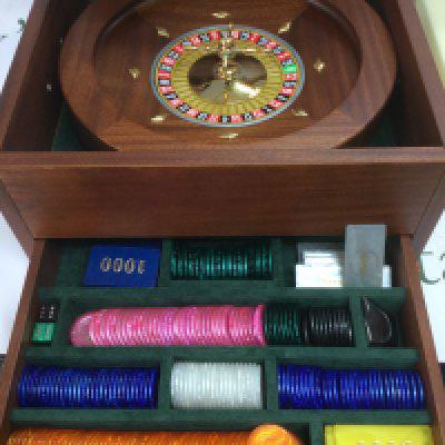 A boxed roulette wheel with gaming tokens, dealer shoe base and cards and other accessories. Shipping category D. NO RESERVE