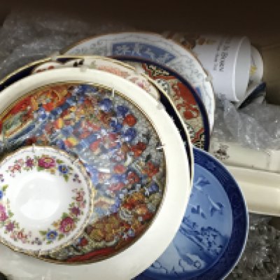 A box containing a large collection of commemorative ceramic mugs and decorative plates. NO RESERVE
