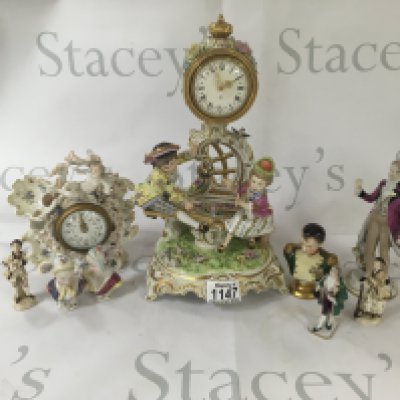 A collection of small busts with ceramic figures and a ceramic clock.