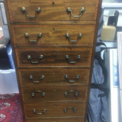 A Edwardian mahogany wellington style chest with cross banding fitted with Seven drawers on bracket feet. 40 x37 cm height 114 cm .