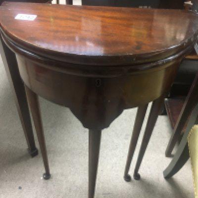 A small Georgian style mahogany Demi loom table the twin flap top above tapering legs .