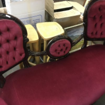 A Victorian double ended sofa with button back upholstery on carved Cabriole legs .