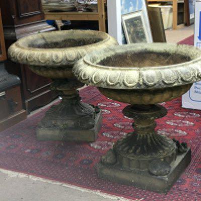 A pair of late 19th century elaborate Neo Classical garden urns composition but not concrete. the wide tops with a moulded edge on a shaped column the square bases with raised corner shell motif. Diameter 65cm height 56cm. Very slight crack see image to one edge and minor chips.