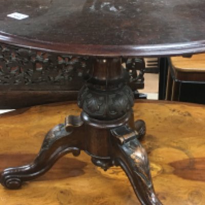 An apprentice style loo table the oval top above a carved turned column on Scrolled legs .