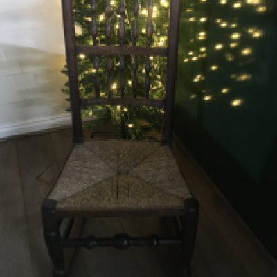 A Elm rocking chair with spinal back and rush seat .