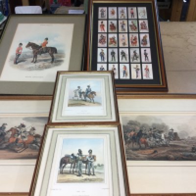 A collection of military pictures and framed cigarette cards.