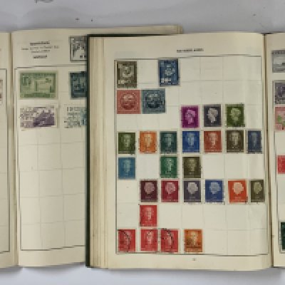 A collection of vintage stamp albums and loose stamps.