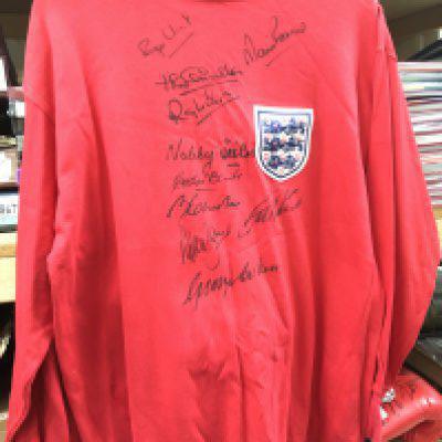 A 1966 England Football World Cup signed shirt, the replica shirt signed by 10 players in black felt (does not include Bobby Moore). Comes with COA. Shipping category B.
