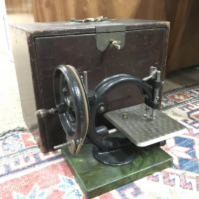 A vintage cased hand crank cast iron sewing machine. This lot cannot be posted