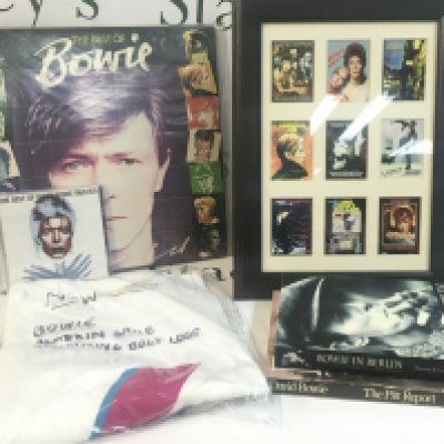 A Collection of David Bowie ephemera including book Bowie in Berlin, The Pitt Report, T-shirt, Best of Bowie record etc. this lot can be posted without the picture frame.