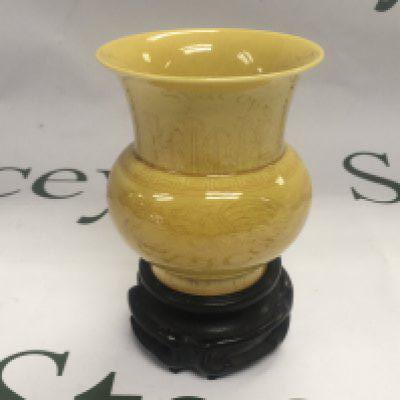 A small yellow glazed vase with six character marks to bas and raised on a carved hardwood base, approx total height 13cm. Shipping category D.