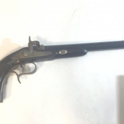 A 19th Century French Percussion Target Pistol or dulling pistol with walnut carved grip with an octagonal Damascus barrel. Engraved steel action Le Fever. The action works.