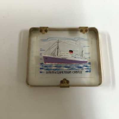 A collection of Union castle line items consisting of a side plate in decorative company pattern from the Union castle line, souvenir chrome ashtray from the Union castle line vessel the RMS Arundel castle, silver plated dining table salt pot from the Union castle line vessel the walmer castle, souvenir cigarette case showing the RMMV Cape Town castle, souvenir tea caddy spoon from the Union castle line vessel the RMMV Athlone castle and very early 1920s design cake stand from the Union castle line