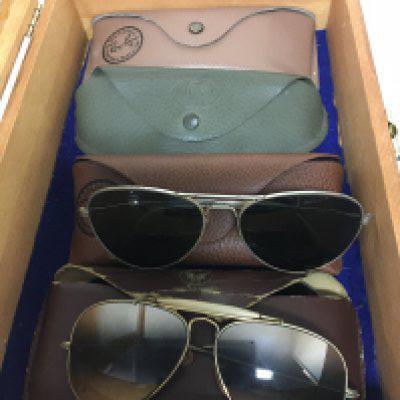 A collection of four pairs American 1940s and later Ray Ban sun glasses most likely worn by II world war American Military personnel one case stamped 1945 US Polaroideach pair with case in a wood display box. (4)