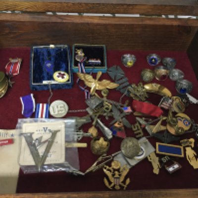 A case containing American military and other badges including an enamel ring 14th Armoured Division American Paratroopers other rings and associated badges.