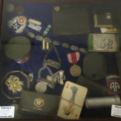 A Case containing American Airborne enamel badges ID bracelet a white metal US Army bracelet. And other associated items.