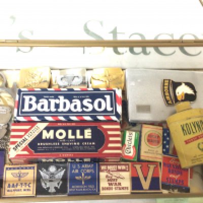 A display case containing II world war American military related items books of matches Airborne cigarette case and other items.