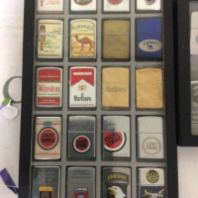 Two Cases containing Zippo lighters some American military related and others.