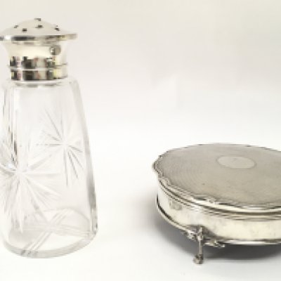 A hallmarked silver trinket box, together with a silver topped cut glass sugar sifter. This lot cannot be posted