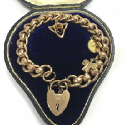 A 9ct gold bracelet with charms and a padlock heart. 23.82g Postage B