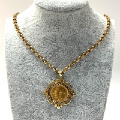 A George V half sovereign with a 9ct gold coin mount and chain. (A)
