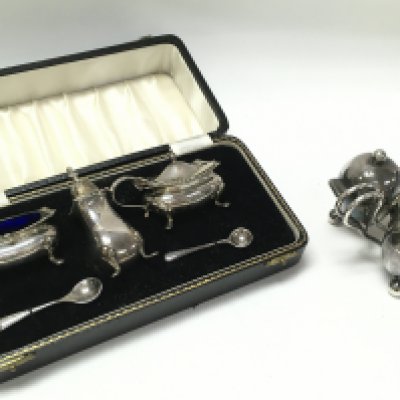A cased silver hallmarked cruet and a plated set. Postage category B