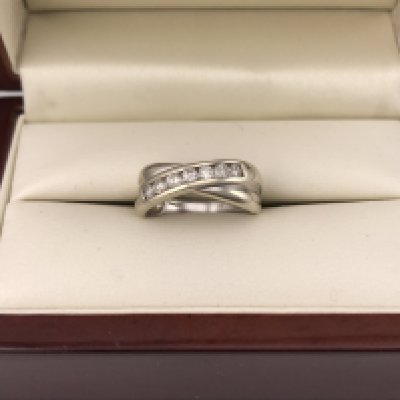 A 9ct white gold diamond set crossover style ring. Approx weight 3.61 grams, approx size L.