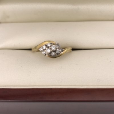 An 18ct diamond crossover cluster style ring. Approx 4.68 grams, size M1/2.