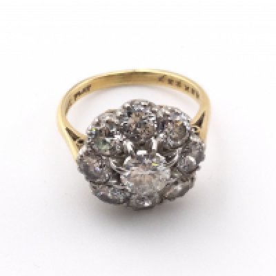 An 18k gold and platinum diamond cluster ring. Size J and 4.25g. Centre stone is approx 0.50ct Postage A