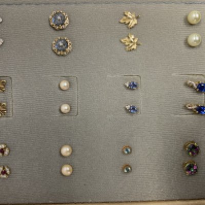 A small stud earring book, including a collection of silver and gold stud earrings.