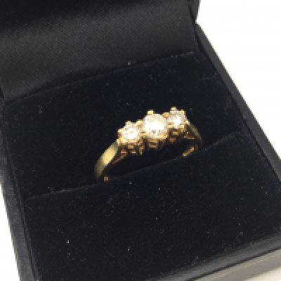An 18ct gold three stone diamond ring. Approx weight 3.34 grams, size M.
