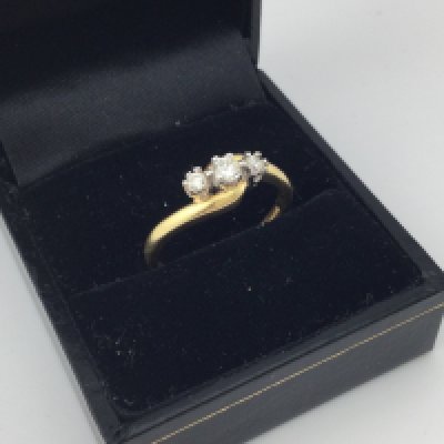 An 18ct gold diamond three stone ring. Approx weight 3.44 grams, size Q.