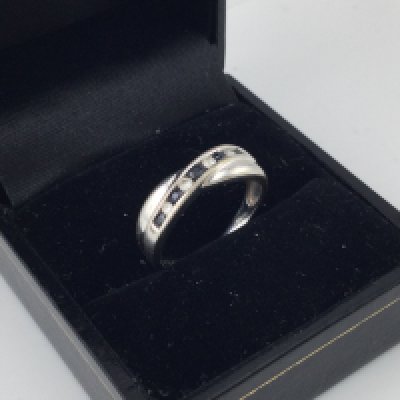 A 9ct white gold almond and sapphire crossover ring. Size L.