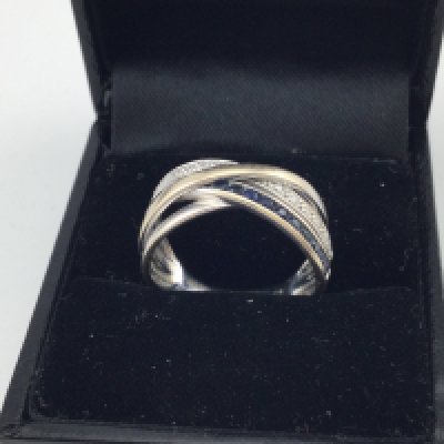 A 9ct white gold diamond and sapphire crossover ring. Approx weight 3.3 grams. Size o.