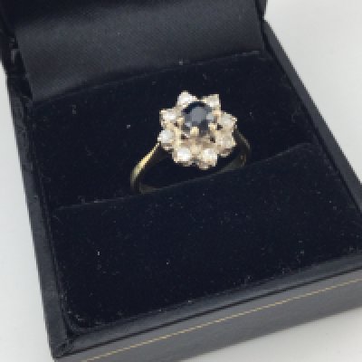 A yellow metal diamond and sapphire cluster ring.