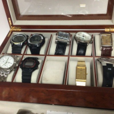 A walnut watch case containing gents designer watches digital watches and copy watches sold as seen.