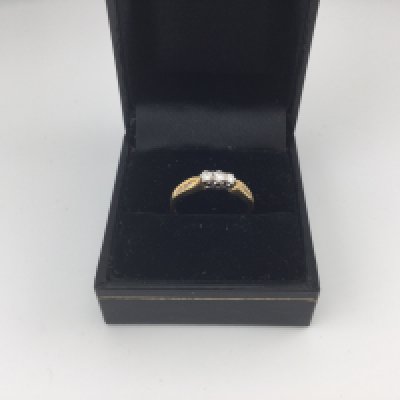 An 18ct gold three stone diamond ring. Approx weight 2.42 grams, size N.