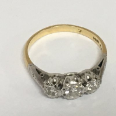 An 18carat gold and platinum ring set with a row of three diamonds. Ring size R weight 2.8g