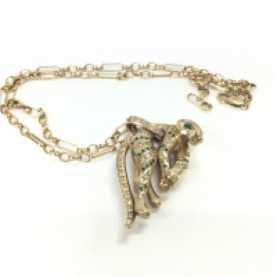 A Cartier (serial number 271139) jaguar stone set pendant (tested 14ct) on a 9ct gold belcher Figaro style necklace. Pendant weight approx 32.12 grams, necklace weight 9.52 grams.