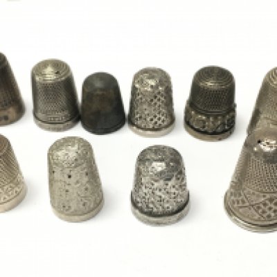 A collection of silver thimbles , postage category A