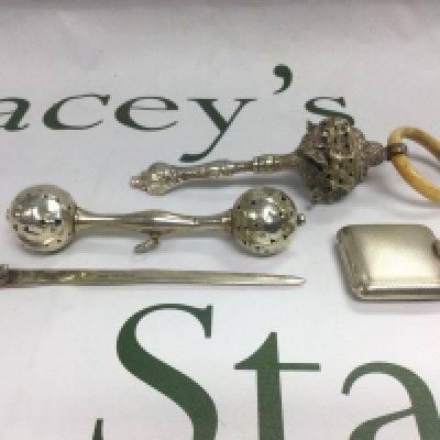 Two silver rattles a silver cased travel clock and a silver bookmark (4). Shipping category B.