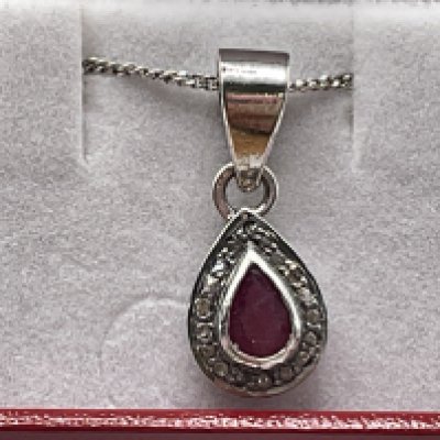 Silver pear shaped pendant set with pear shaped ruby and a halo of R/C diamonds, boxed. Ruby 0.28ct approx. Diamonds 0.51ct approx. Postage category A.