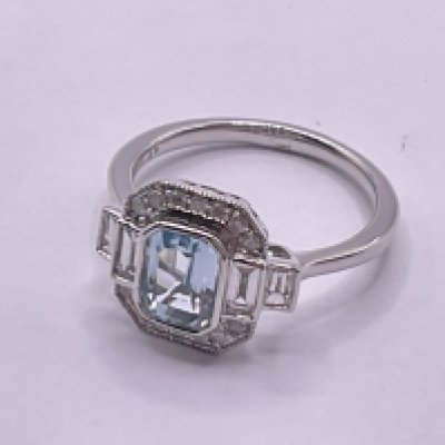 9ct white gold step cut Swiss blue topaz, RBC and baguette cut diamond Art Deco style dress ring. Topaz 1.03ct, diamonds 0.46ct. Ring size approx K/L. Postage category A.