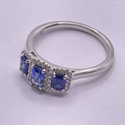 Platinum trilogy ring set with step cut sapphires each surrounded by RBC diamonds. Sapphires 0.83ct. Diamonds 0.14ct. Ring size approx M. Postage category A.