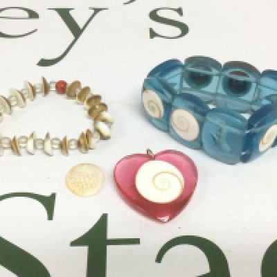 Four items of Operculum jewellery. Shipping category A.