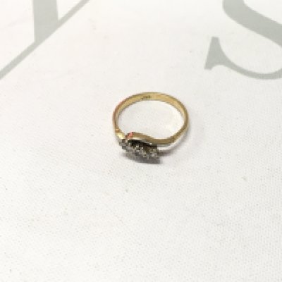 An 18ct gold three stone diamond crossover ring. Approx weight 2.1 grams, Approx size J.