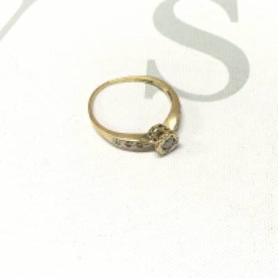 An 18ct gold solitaire ring with stone set shoulders. Approx weight 2.4 grams, Approx size P.