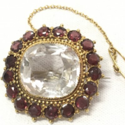 An Edwardian brooch set with garnet stones . Postage category A