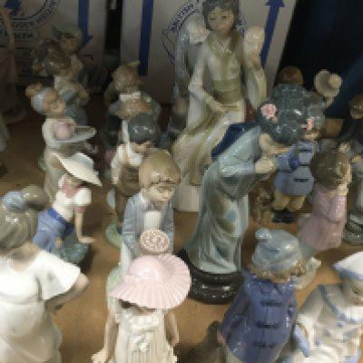 A collection of Nao figures including two large Geisha and boy with skateboard