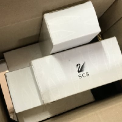 A box containing a large number of Swarovski plaques and stands for display